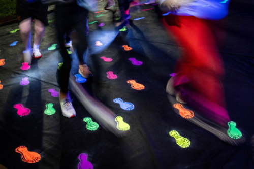 Runners run over glow-in-the-dark footprint stickers at night