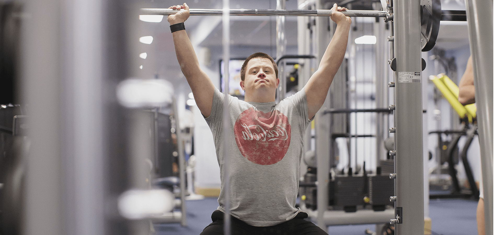 Man lifting weights in gym while seated