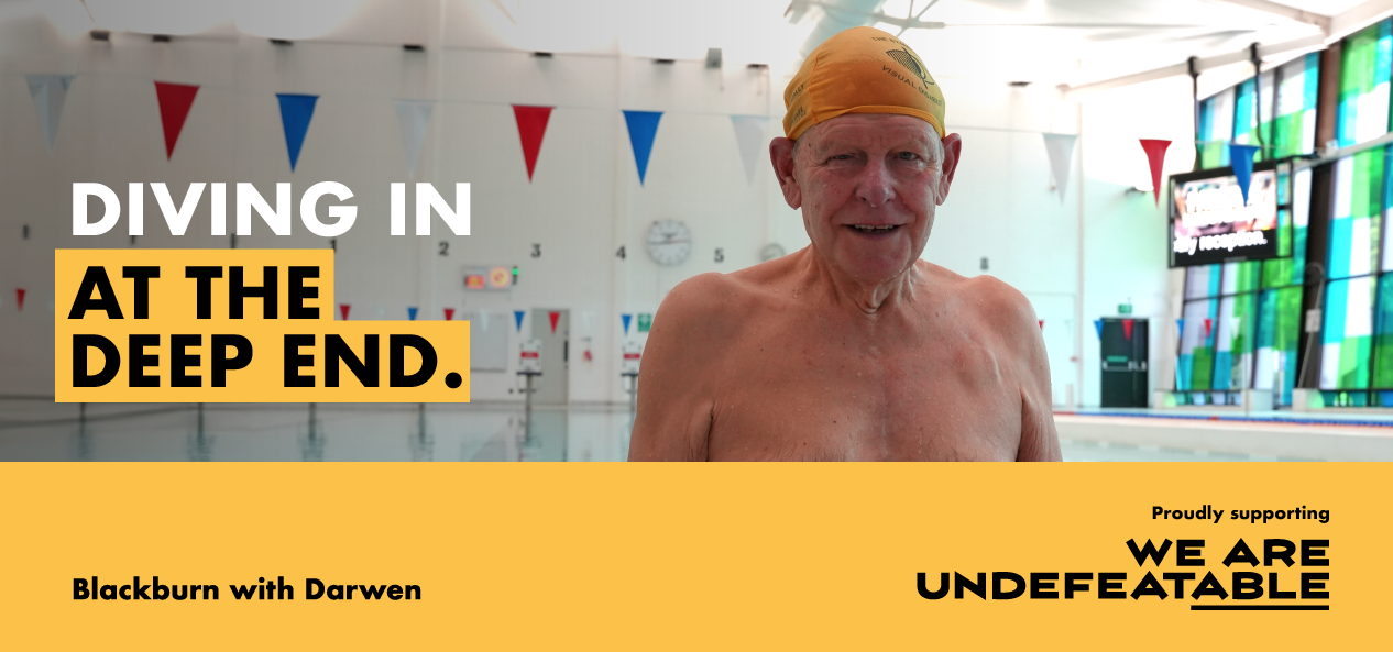 An old gentleman is seen bare chest and witha swimming cap on with an indoors swimming pool behind him. The words" Diving in at the deep end." appear to his right and behind him and over a yellow rectangle on the bottom left it says "Blackburn with Darwen" and then on the bottom right the copy says "Proudly supporting We Are Undefeatable" and the suffix "able" is underlined.