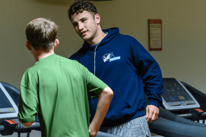 Volunteering gym trainer talking to jogger