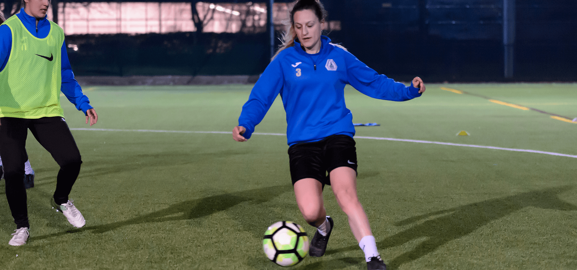 Woman dribbling during football game outdoors