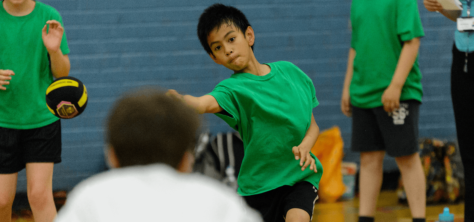 Young boy throwing ball to teammate