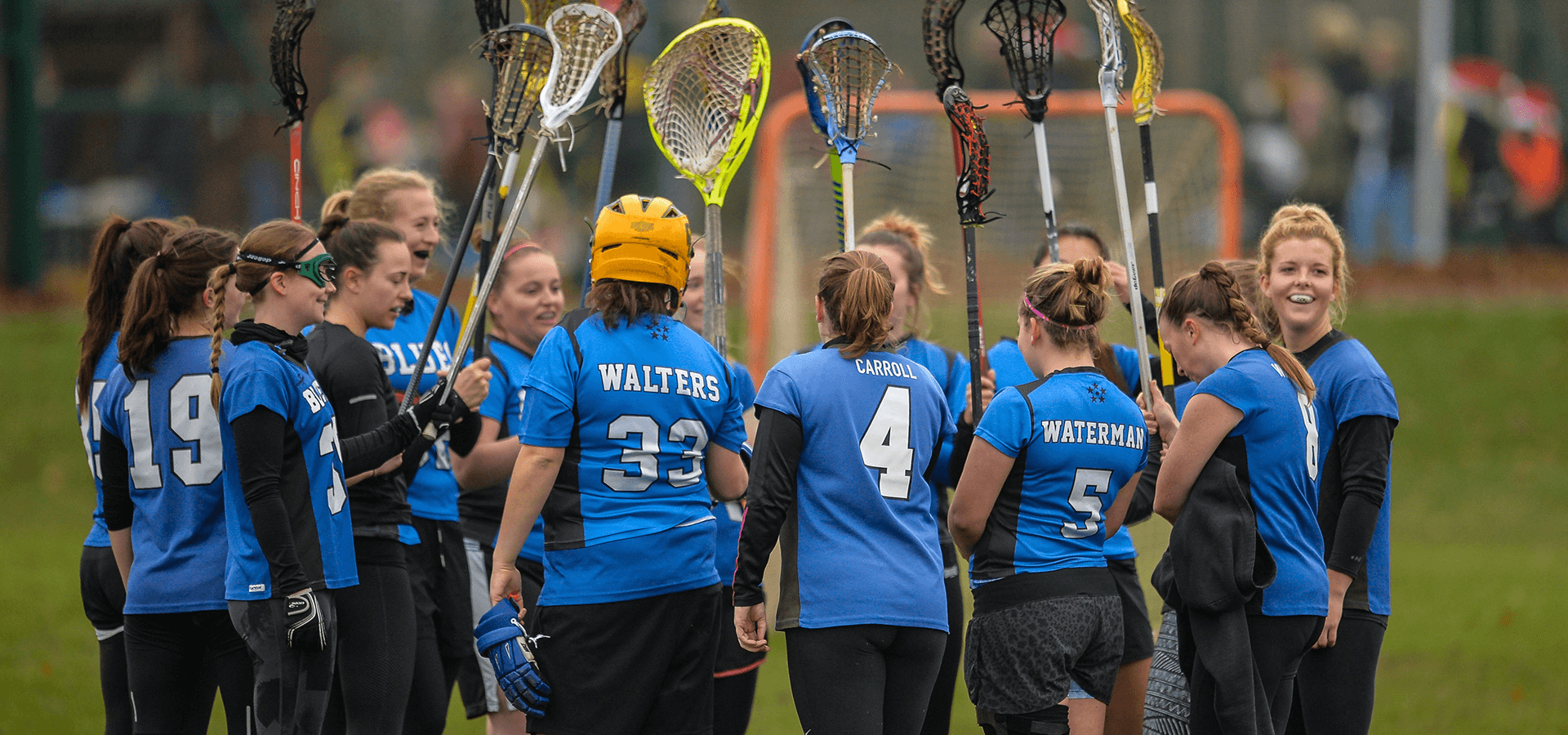 Young female lacross players huddled up before game