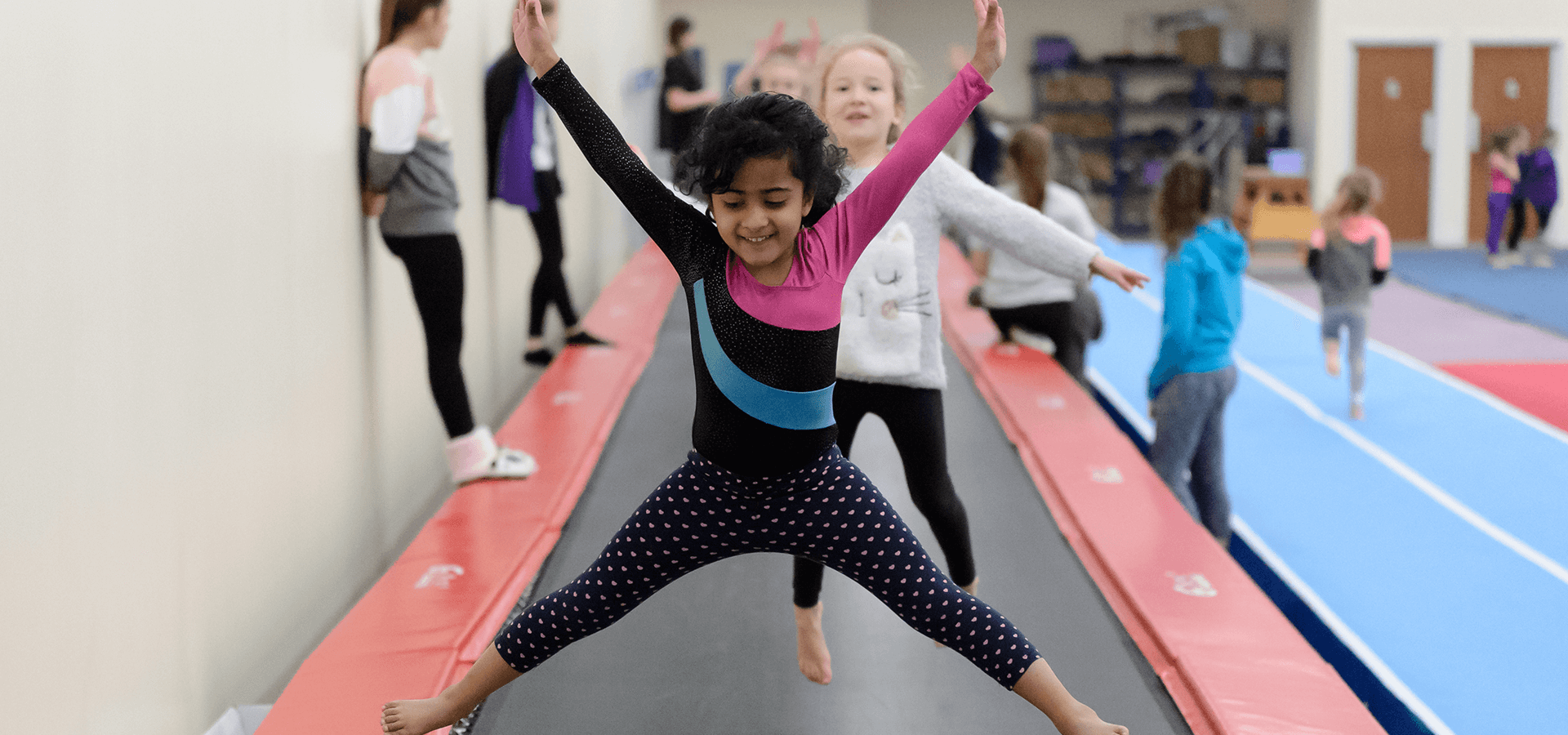 Young girls jumping on long trampoline